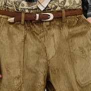 Close-up of a person wearing brown corduroy trousers, a brown belt with a silver buckle, a patterned waistband, a striped shirt, and a striped tie.