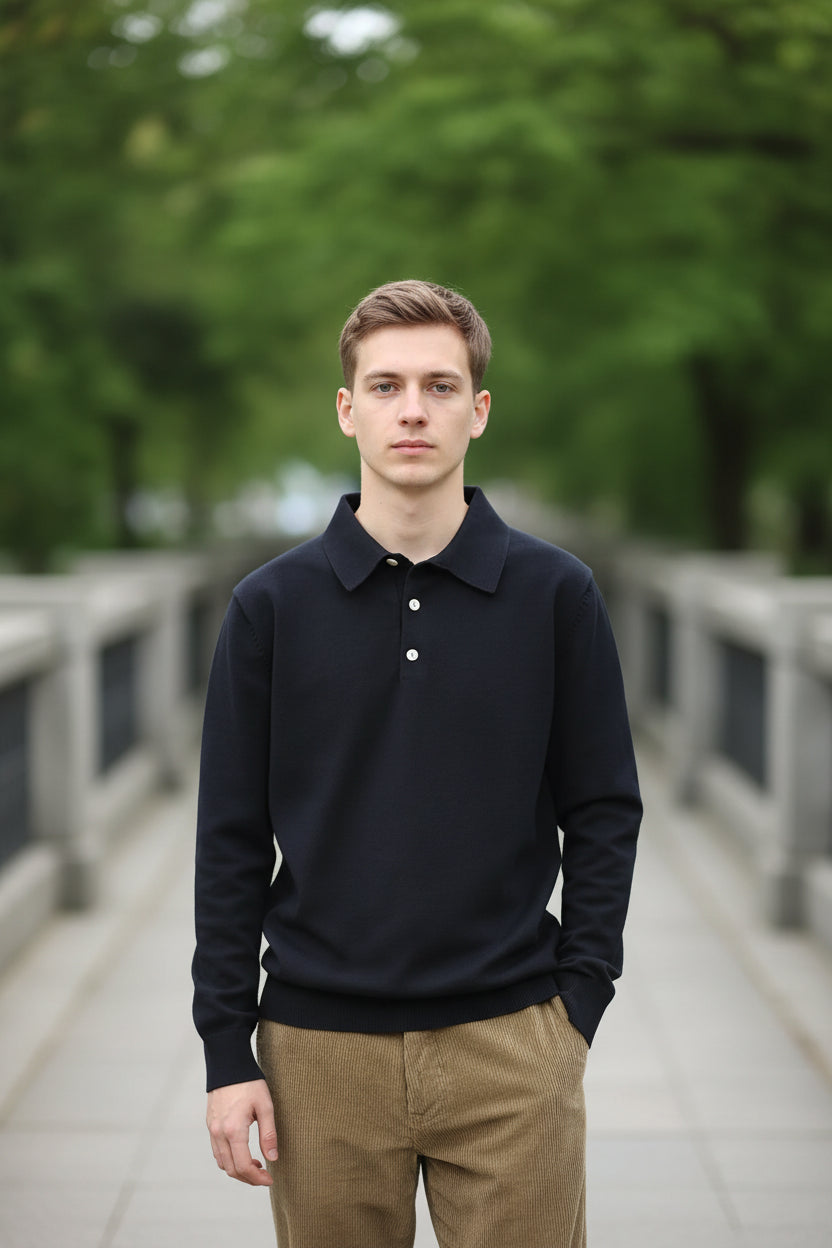 Person wearing a black long-sleeve polo shirt with a collar against a green background