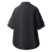 A black short-sleeve button-up shirt shown from the back, featuring a central seam and rolled cuffs with button details, set against a plain white background.