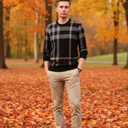 Person wearing a black and gray plaid sweater on a gray background