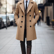 Man wearing a beige overcoat with a blurred city street background