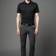 Black polo shirt worn by a person on a gray background