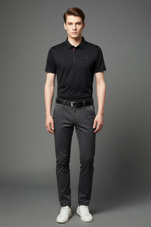 Black polo shirt worn by a person on a gray background