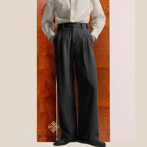 Person wearing a white shirt and dark pinstripe pants against a wooden panel background