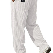 White corduroy pants with a vertical striped texture, featuring a back pocket with a black label and styled with white sneakers, 