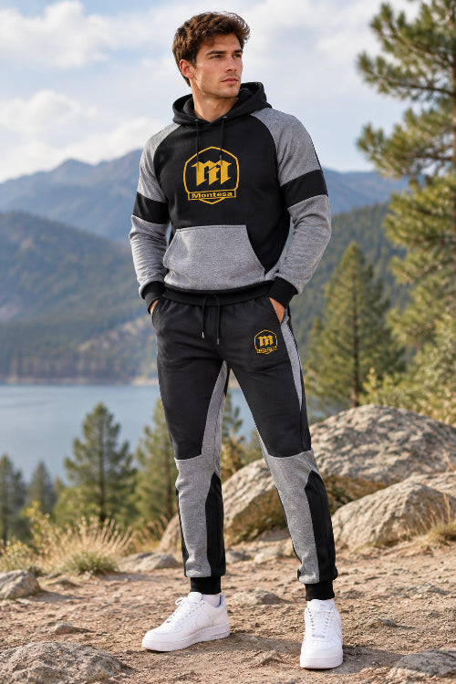 A two-piece athletic tracksuit set featuring a black and gray color-blocked hoodie with a yellow Montesa logo on the chest, and matching jogger pants 