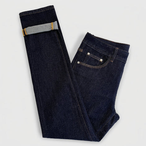 Dark indigo blue jeans folded on a white background, showing the front pocket, belt loop, and rolled cuff revealing a lighter gray inner lining.