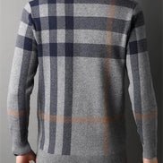 Plaid sweater with a gray and navy pattern on a plain background