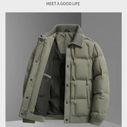 A men's puffer jacket in muted sage green, shown open to reveal a black interior lining. The jacket features a ribbed collar, cuffs, and hem, and is displayed against a gray background with promotional text at the top.