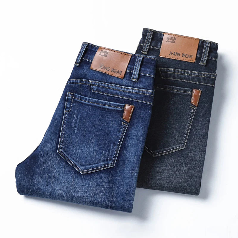 Pair of blue jeans with brown leather patches on a white background