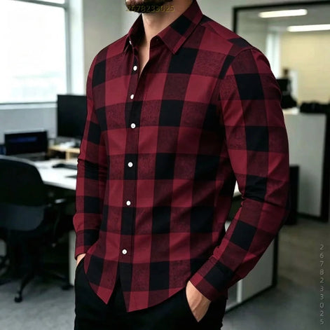A man wearing a long-sleeve button-up shirt with a red and black buffalo plaid pattern, standing in an office environment.