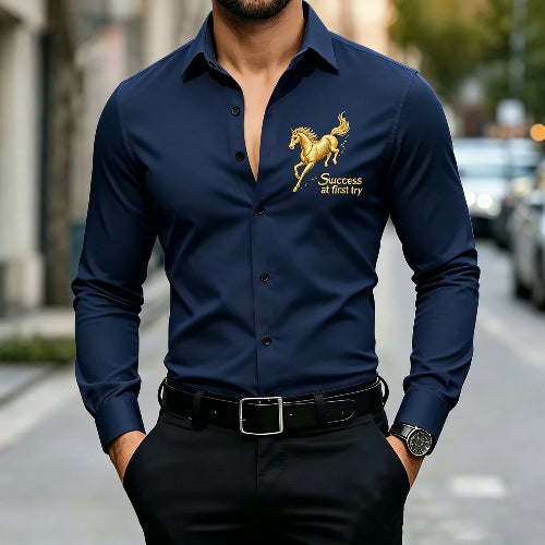 A man wearing a navy blue long-sleeve button-up shirt with a gold embroidered horse and the words 'Success at first try' on the left chest, 