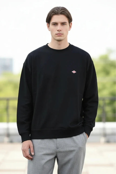 Black sweatshirt with a small red logo on a white background