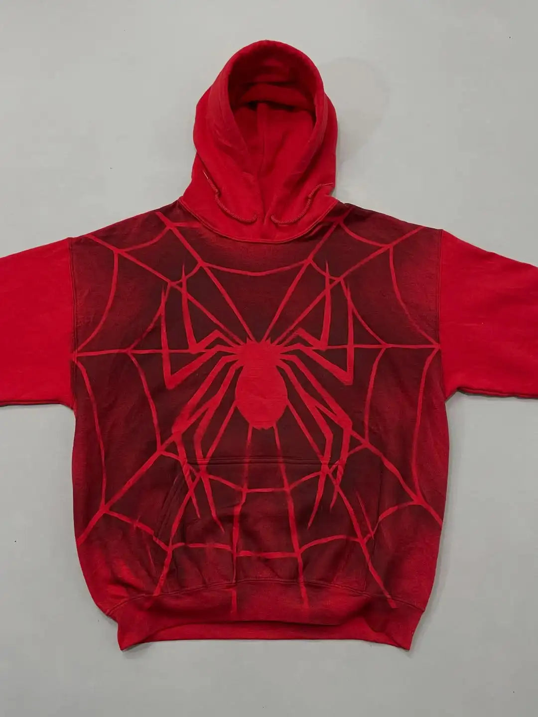 Red hoodie with spider web design on a gray background