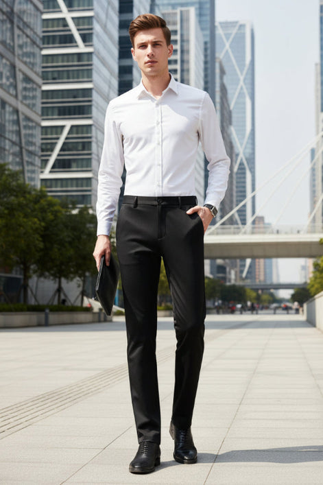A man wearing slim black dress pants, a white dress shirt, and black dress shoes, holding a black clutch. The Langbeeyar brand logo is visible in the top left corner against a dark gray studio background.