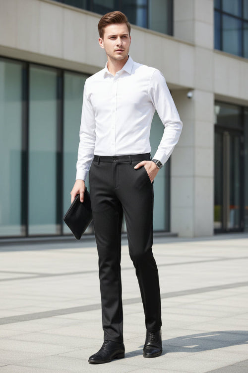 A man wearing slim black dress pants, a white dress shirt, and black dress shoes, holding a black clutch. The Langbeeyar brand logo is 