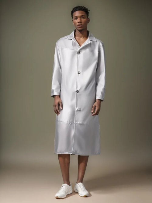 Person wearing a long white lab coat against a neutral background