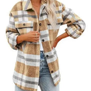 Woman wearing a tan and gray plaid shirt with jeans, against a white background.