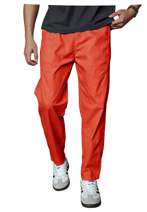 A person wearing bright orange-red tapered pants with a dark gray shirt and white sneakers, 