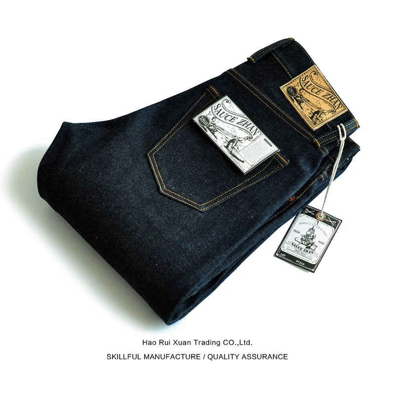 Folded dark blue jeans with brand tags on a white background