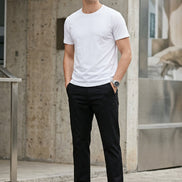 A person wearing black straight-leg pants, a white t-shirt, and white sneakers, standing against a gray studio background. A vertical label on the left reads '真宏' (Black).