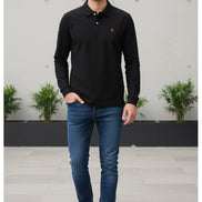 Black polo shirt with a red logo on a hanger