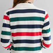 A woman shown from the back wearing a long-sleeve collared shirt with horizontal stripes in white, navy blue, green, and red.