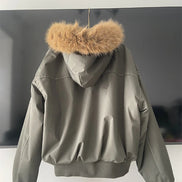 Green jacket with fur hood on a white surface