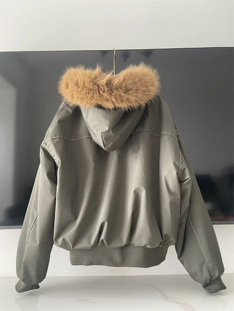 Green jacket with fur hood on a white surface