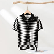 Black and white striped polo shirt on a hanger against a white background