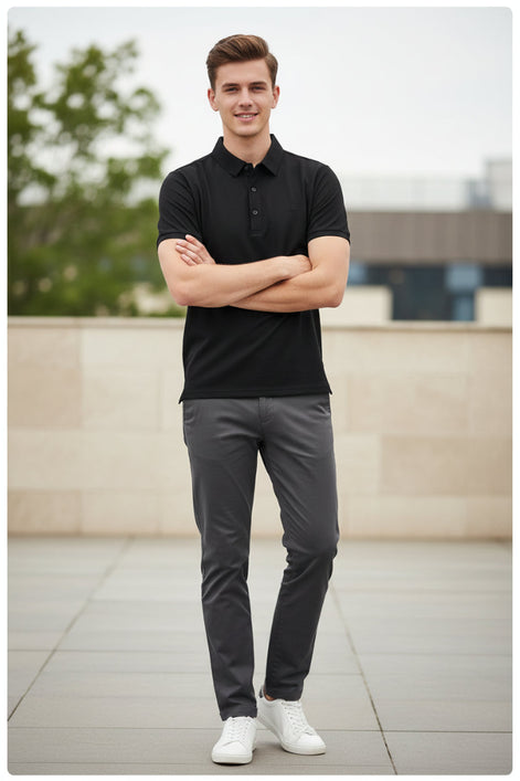 A black short-sleeve polo shirt hanging on a black hanger in a retail clothing display, with other garments visible in the background.