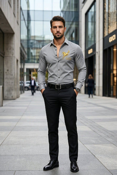 A man wearing a fitted long-sleeve gray dress shirt with a gold horse logo and the words 'Success at Party' on the left chest, paired with black trousers and a black belt, standing on a blurred city street.