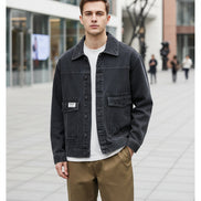 Person wearing a black denim jacket on a white background