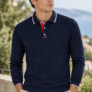 A navy blue long-sleeve polo shirt with a red and white striped collar and matching striped placket 