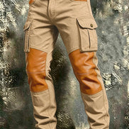Khaki cargo pants with tan contrast panels at the knees and front pockets, flap thigh pockets, and a brown belt against a textured gray background.