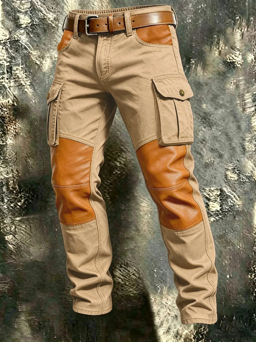 Khaki cargo pants with tan contrast panels at the knees and front pockets, flap thigh pockets, and a brown belt against a textured gray background.