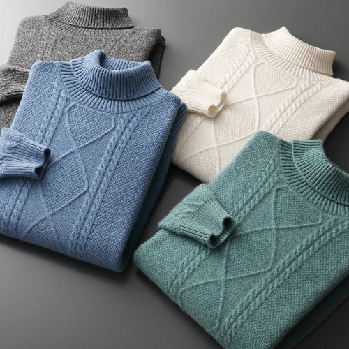 Four folded knit mock-neck sweaters arranged on a dark gray surface, shown in gray, light blue, mint green, and off-white. Each sweater has a ribbed mock neck and sleeve, 