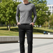 Person wearing black pants and brown shoes on a gray background