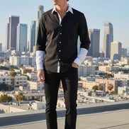 Man standing on a rooftop with a cityscape in the background