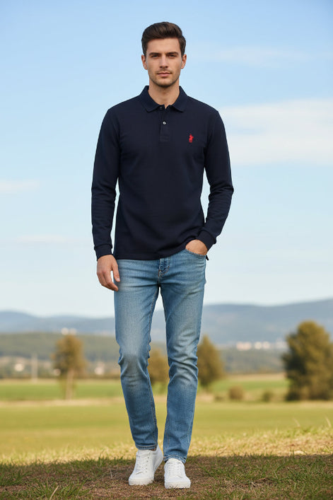 Navy long-sleeve polo shirt with red logo on a hanger against a rack of other shirts.