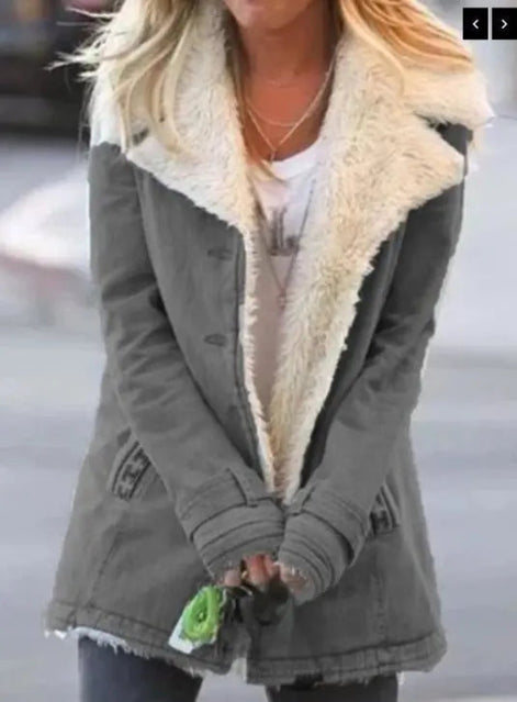 Woman outdoors wearing a gray coat with wide cream fleece-look lapels, front pockets and cuff tabs over a white top