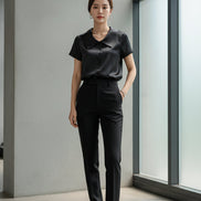 Black satin shirt on a hanger with a neutral background
