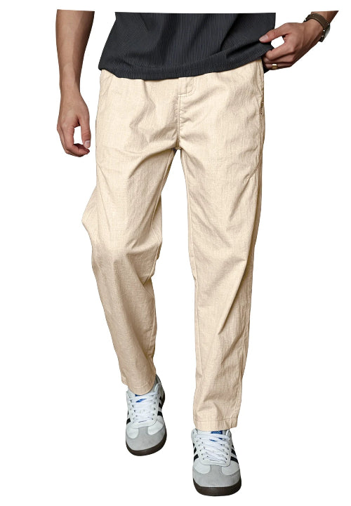 A person wearing light beige relaxed-fit pants, a dark gray ribbed t-shirt, and white sneakers, shown from the waist down against a plain white background.