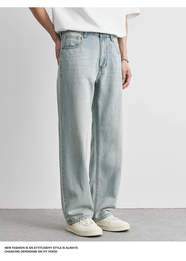 Person wearing light blue jeans and a white shirt on a plain background