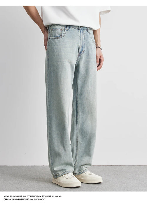 Person wearing light blue jeans and a white shirt on a plain background