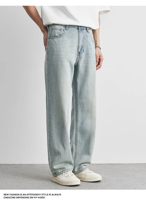 Person wearing light blue jeans and a white shirt on a plain background