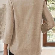 Beige blazer worn by a person indoors with a blurred background