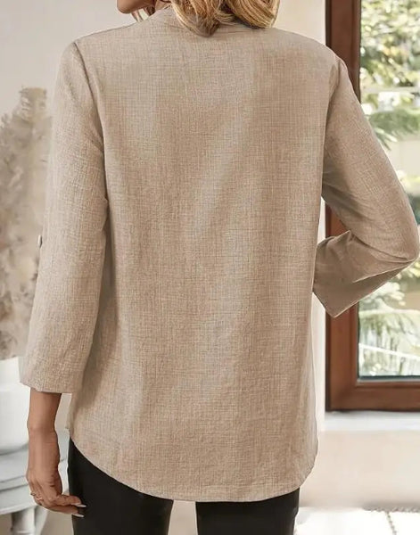 Beige blazer worn by a person indoors with a blurred background
