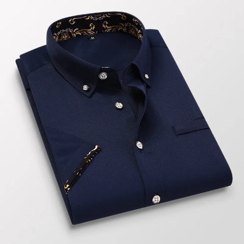Folded navy blue dress shirt with patterned collar on a light gray background