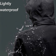 Person wearing a black raincoat with water droplets on a dark background, labeled 'Lightly waterproof'.